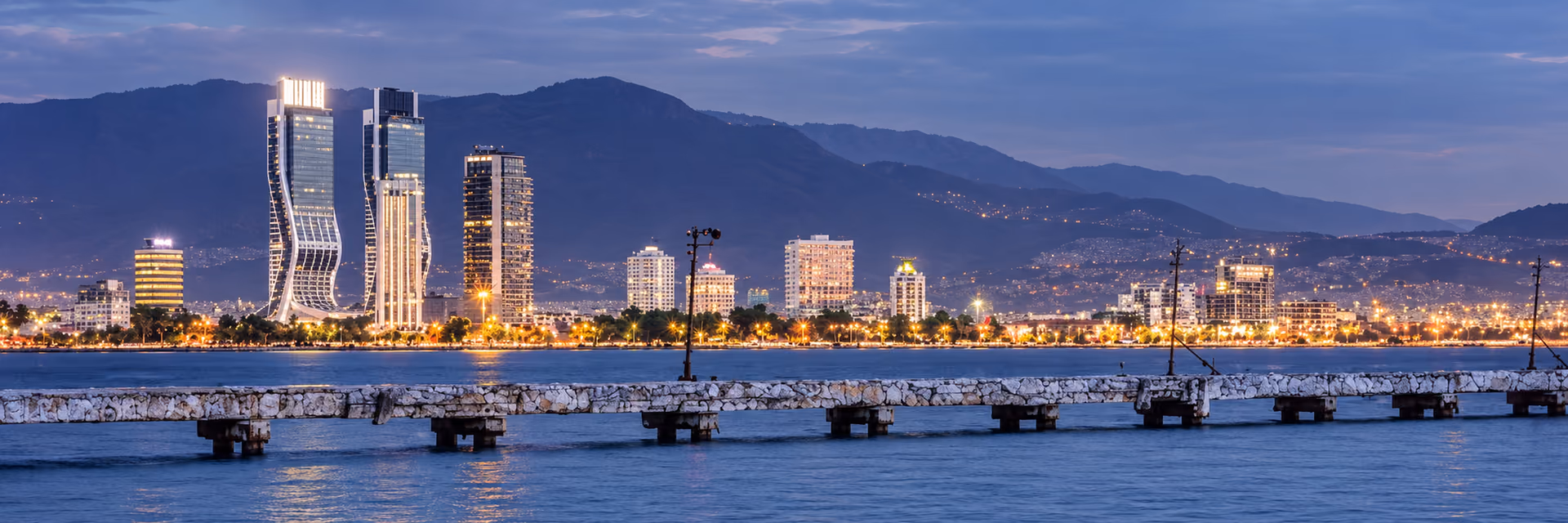 Akşam ışıklarıyla İzmir kıyısı ve şehir silueti